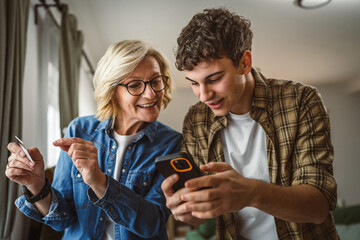 Wall Mural - mother and son woman young man shopping online at home use credit card