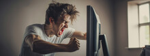 Enraged Young Man Punching A Computer Monitor