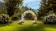 une arche de ballons blancs et dorés installée dans un parc pour un mariage, anniversaire ou une réception