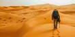 Explorer carrying a backpack walking through the desert from behind	