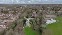 An Aerial View Of Bradwell Windmill In Milton Keynes On A Cloudy Day, Buckinghamshire, England, UK. Flying Left To Right Around The Windmill At Far Distance.