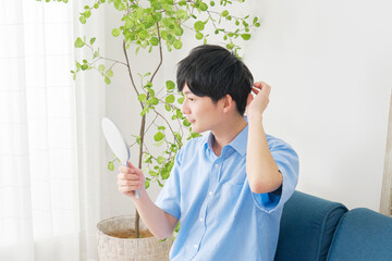 Poster - 鏡を見て髪型を整える若い男性