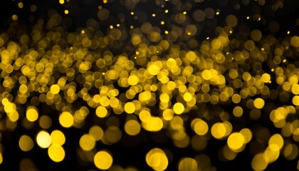 Defocused golden yellow color flecks and bokeh on dark black abstract background