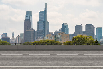 Empty urban asphalt road exterior with city buildings background. New modern highway concrete construction. Concept way to success. Transportation logistic industry fast delivery. Philadelphia. USA.