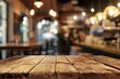 a rustic wooden board serving as an empty table, positioned in front of a blurred background reminiscent of a bustling coffee shop