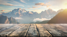 A wooden deck overlooking a mountain range with a clear blue sky. The view is serene and peaceful, with the sun shining brightly on the mountains. The wooden deck is a perfect spot to relax