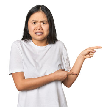 Young chinese woman isolated shocked pointing with index fingers to a copy space.