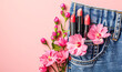 © alla.naumenco - In the pocket of my jeans there are some lipsticks with flowers next to them. light pink background.