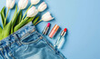 © alla.naumenco - In the pocket of my jeans there are some lipsticks with flowers next to them. light blue background.
