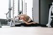 © Westend61 - Mature woman doing stretching exercise in gym