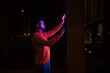© Westend61 - Man using touch screen kiosk machine on street at night