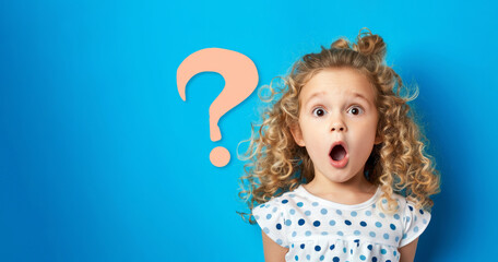 a kids girl with curly hair is standing in front of a blue wall with an exclamation point on it. sta