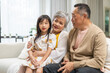 © Art_Photo - Portrait of happy love asian grandfather with grandmother and asian little cute girl enjoy relax at home.Young girl with their laughing grandparents smiling together.Family and togetherness