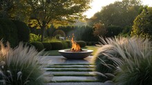 A Sculptural Fire Pit Nestled Amidst Sculpted Hedges And Ornamental Grasses, Offering Warmth And Ambiance.