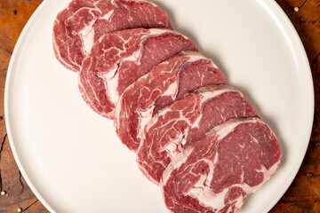 Canvas Print - Raw beef ribeye meat. Butcher products. Fresh beef ribeye meat on dark background. Top view