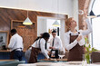 © AnnaStills - Selective focus shot of ethnically diverse waiting staff cleaning tables and polishing glassware in modern restaurant