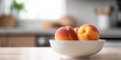 Peaches in a bowl on the kitchen table on a blurred background