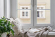 © brizmaker - Windowsill with decorative cushions, soft plaid and open book in cozy apartment