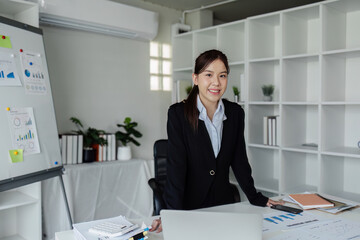 successful businesswoman standing and looking confident at camera