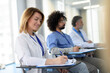 © Halfpoint - Group of doctors on conference, medical team sitting and listening speaker. Medical experts attending an education event, seminar in board room.