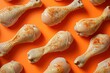 Delicious chicken drumsticks arranged on orange background with assorted spices seasoning on top