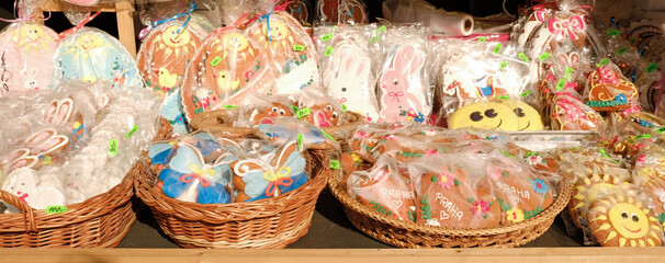 Wall Mural - Traditional Easter gingerbread cookies in the shape of a colorful egg with drawings of a hare and chickens are sold at a market