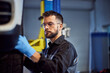 © bnenin - Focused mechanic working at his garage, checking a car wheel.