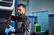 © bnenin - Mechanic holding a car wheel, fixing a problem, working at the car repair service.
