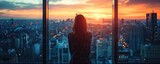 Fototapeta  - Woman contemplating cityscape through a window at sunset