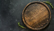 empty round wooden tray with rosemary branch on a dark background with space for products, text or inscriptions