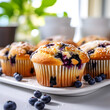 Close up of blueberry muffins on kitchen table, blurry bright background 