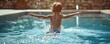Kid jumping in swimming pool with water