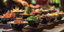 Black Bowls With Various Salads And Fruits On A Buffet Table.