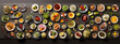 An overhead view of a variety of food dishes and ingredients arranged on a dark surface.