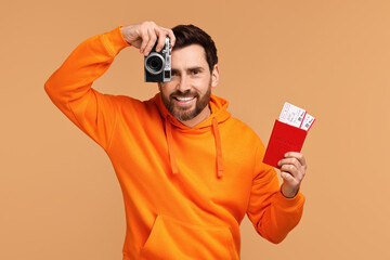 Sticker - Smiling man with passport, camera and tickets on beige background