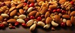 Mix of peanuts and almonds scattered on a warm, beige surface copy space