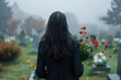 Sad young woman grieving her loss on a cemetery. Lonely widowed wife by the headstone of her spouse.