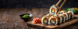 Sushi rolls picked up by chopsticks, ready to eat. Popular Japanese food. Panorama with copy space.