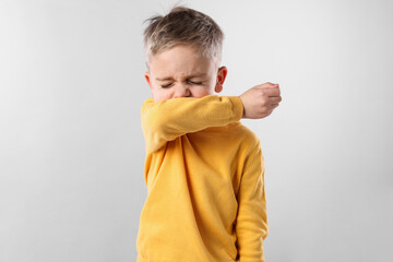 Wall Mural - Sick boy coughing on gray background. Cold symptoms