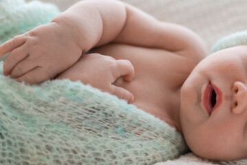 Canvas Print - Cute newborn baby in warm hat sleeping on white plaid, closeup