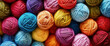 Vibrant assortment of colorful yarn balls in various shades of blue, green, red, yellow and pink arranged together