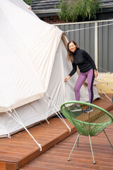 Poster - A woman locks a beautiful glamping tent in a camping