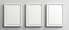 Three Rectangular Picture Frames Made Of Composite Material Are Fixed Onto A White Wall, Creating A Symmetrical Pattern. The Frames Are In Shades Of White And Hung With Metal Fixtures