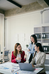 Poster - Three women are sitting at a table in a business setting