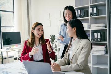 Poster - Three women are sitting at a desk, smiling and talking to each other
