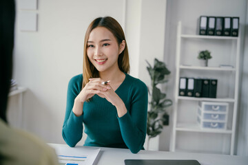 Poster - A woman in a green sweater sits at a desk with a man