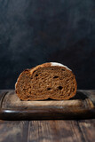 Fototapeta Mapy - half rye bread on a wooden cutting board, vertical
