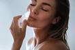 © blackday - Serene Young Woman Applying Ice Therapy to Face