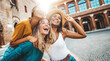 © Davide Angelini - Three multiracial young women having fun walking on city street - Happy girlfriends hanging outside on a sunny day - Different females laughing together outside - Life style and friendship concept