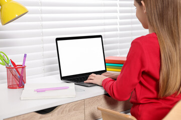 Wall Mural - E-learning. Girl using laptop during online lesson at table indoors, closeup